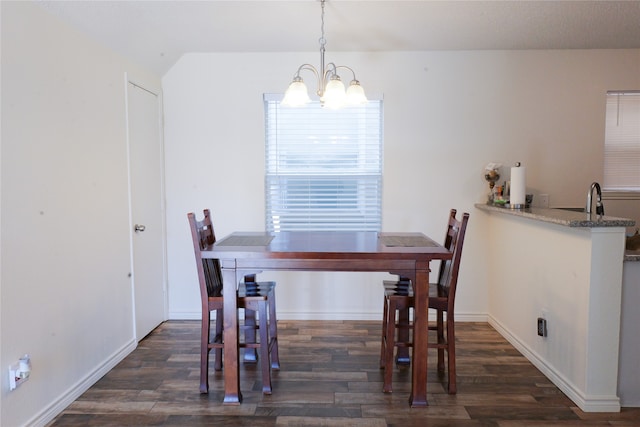 dining room with dark wood-type flooring and a notable chandelier