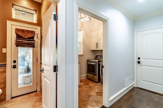 entryway featuring washer and clothes dryer, crown molding, hardwood / wood-style flooring, and an inviting chandelier