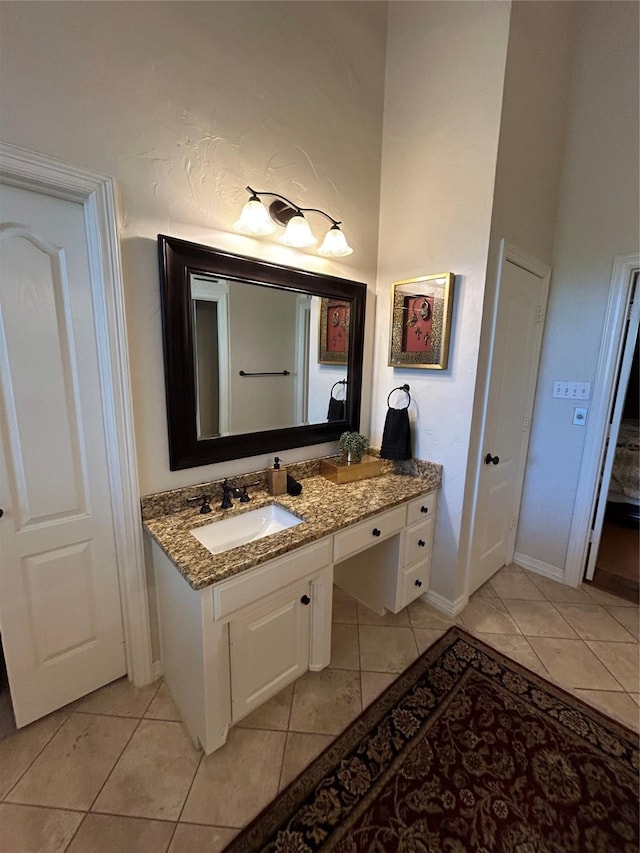 bathroom with tile patterned flooring, a towering ceiling, and vanity