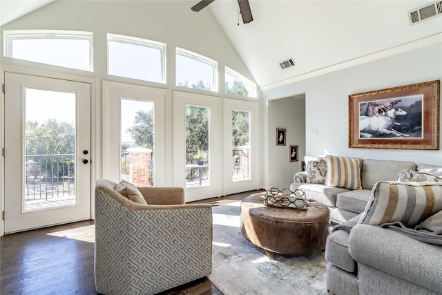 living room with ceiling fan, a healthy amount of sunlight, dark wood-type flooring, and high vaulted ceiling