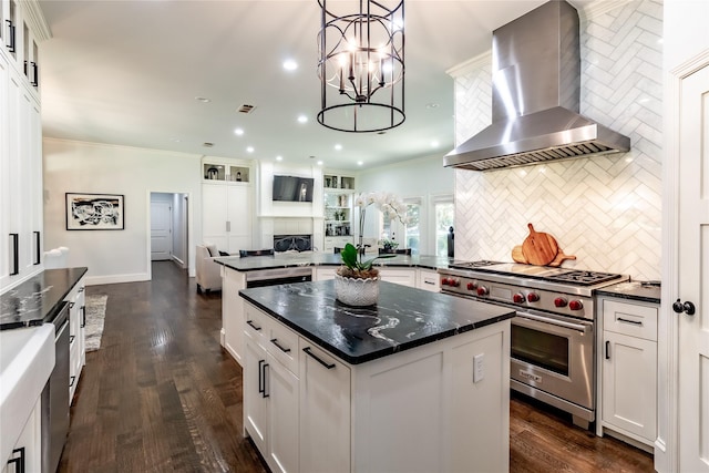 kitchen featuring a center island, white cabinets, wall chimney range hood, decorative backsplash, and designer stove