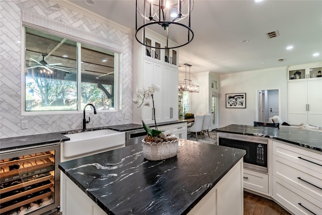 kitchen featuring backsplash, dark stone counters, sink, built in microwave, and beverage cooler