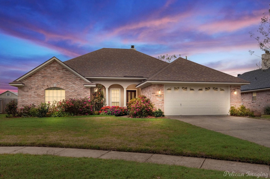 view of front of home featuring a garage and a yard