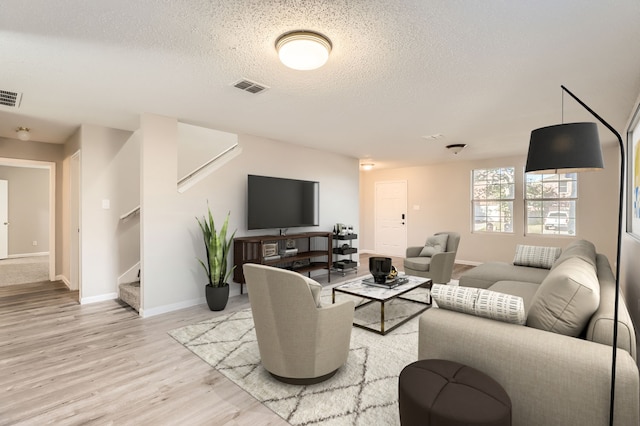 living room with hardwood / wood-style floors and a textured ceiling