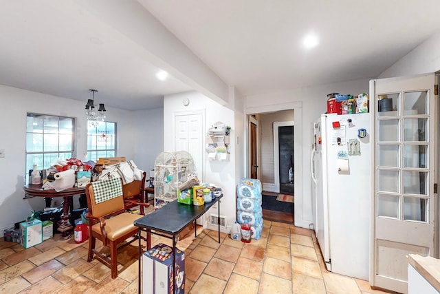 kitchen with a notable chandelier, white fridge, and hanging light fixtures