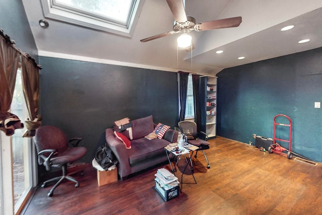 living room featuring ceiling fan, hardwood / wood-style floors, and vaulted ceiling