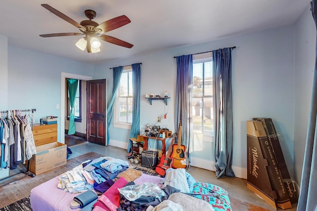 bedroom with wood-type flooring, multiple windows, and ceiling fan