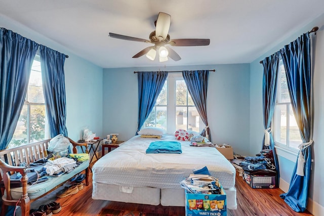 bedroom featuring hardwood / wood-style flooring, multiple windows, and ceiling fan