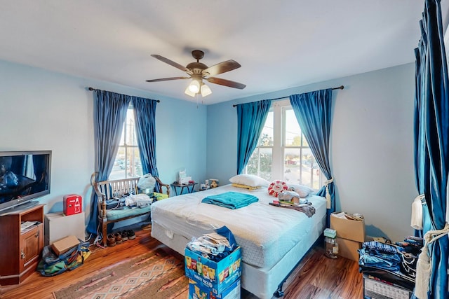 bedroom featuring multiple windows, ceiling fan, and hardwood / wood-style flooring