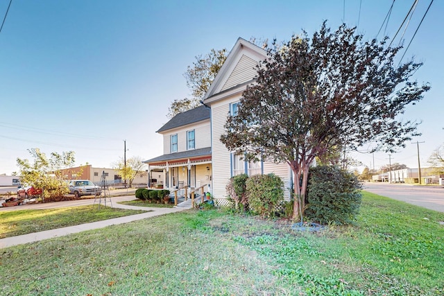 obstructed view of property with a front lawn and a porch