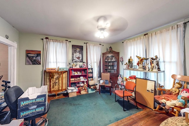 living area featuring hardwood / wood-style flooring and ceiling fan