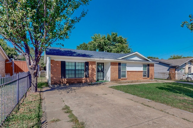 ranch-style house featuring a front yard, brick siding, and fence