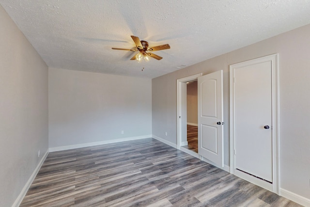 unfurnished bedroom with a textured ceiling, wood finished floors, a ceiling fan, and baseboards