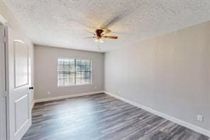 empty room featuring ceiling fan, dark hardwood / wood-style flooring, and a textured ceiling