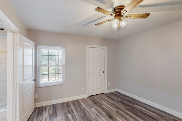 unfurnished room with dark wood-style floors, baseboards, and a ceiling fan