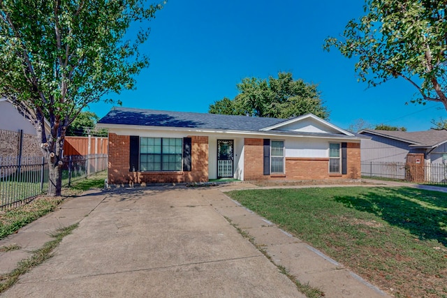 ranch-style home with brick siding, a front yard, and fence private yard