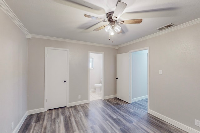 unfurnished bedroom with baseboards, visible vents, dark wood-style flooring, and ornamental molding