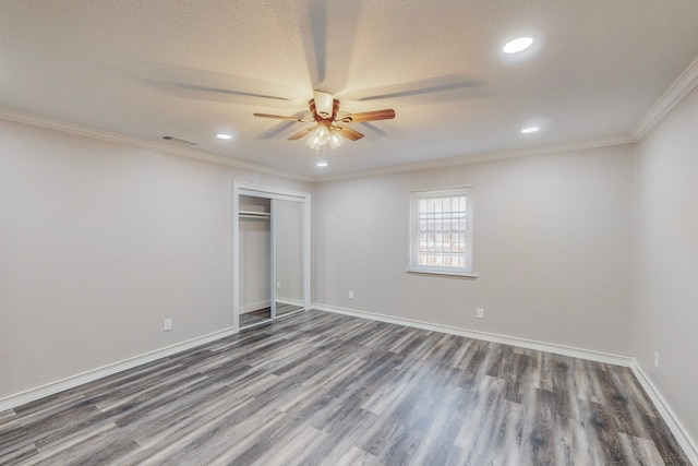 unfurnished bedroom with baseboards, visible vents, dark wood-type flooring, and ornamental molding