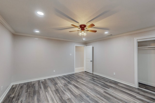 unfurnished bedroom with dark wood-type flooring, recessed lighting, ornamental molding, and baseboards