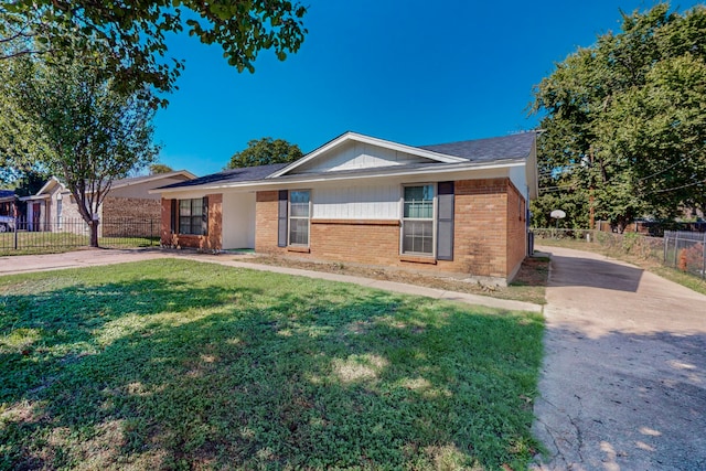 ranch-style house featuring brick siding, a front yard, and fence