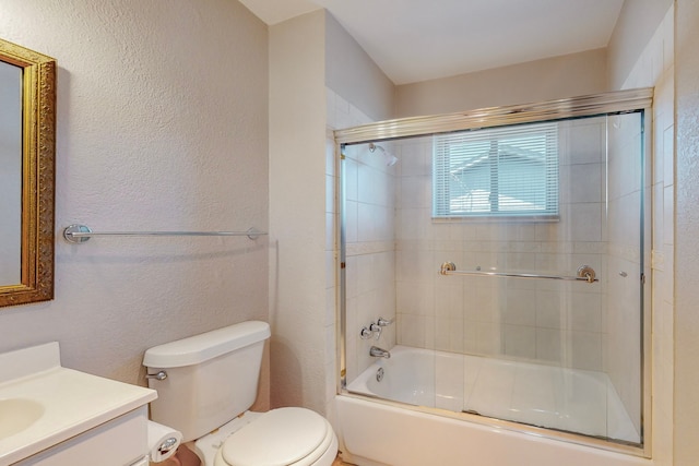 full bathroom featuring toilet, a textured wall, enclosed tub / shower combo, and vanity