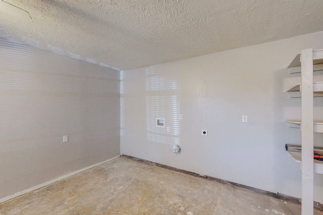 empty room with concrete flooring, a textured ceiling, and baseboards