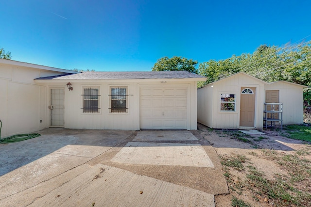 exterior space featuring a garage, concrete driveway, and roof with shingles