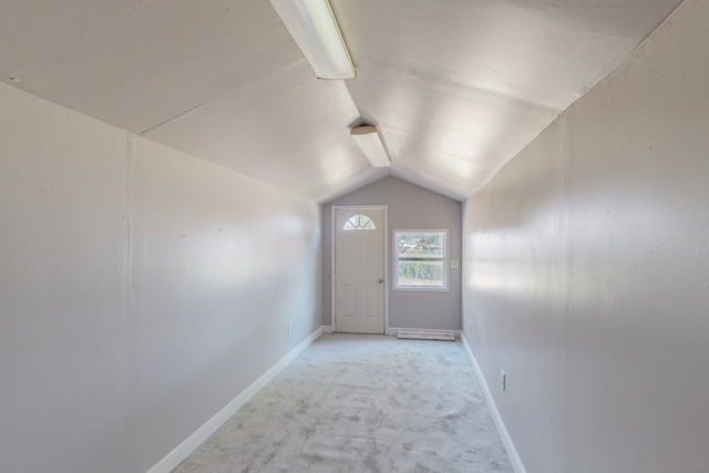 entryway featuring light carpet, lofted ceiling, and baseboards