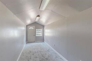 corridor with light carpet and vaulted ceiling