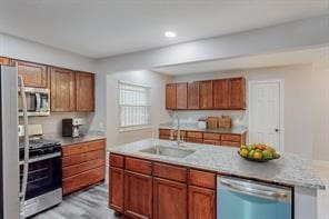 kitchen featuring a kitchen island with sink, sink, and appliances with stainless steel finishes