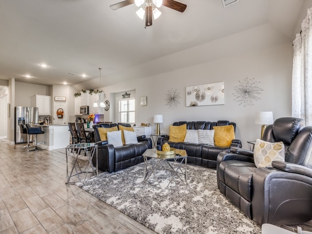 living room with sink and ceiling fan with notable chandelier