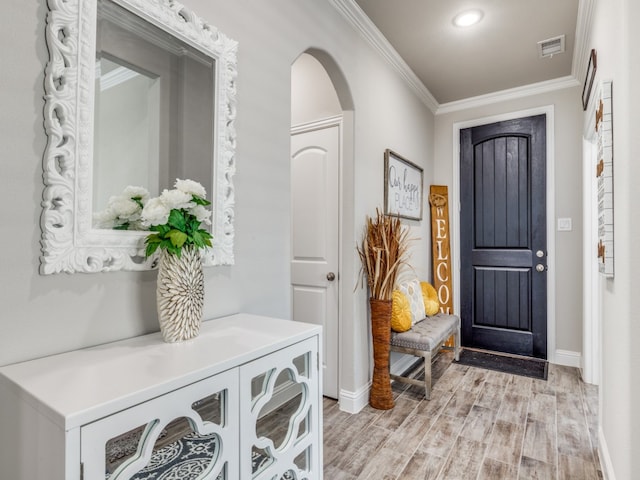 foyer entrance with light wood-type flooring and ornamental molding