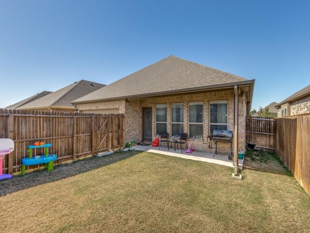 back of property with a patio area and a yard