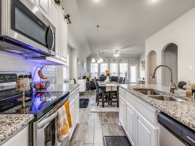 kitchen featuring hardwood / wood-style floors, pendant lighting, sink, appliances with stainless steel finishes, and white cabinetry