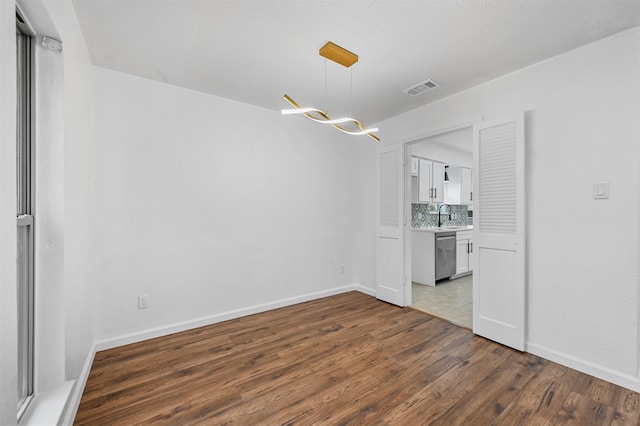 unfurnished dining area with sink and wood-type flooring