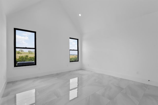 spare room featuring high vaulted ceiling and plenty of natural light