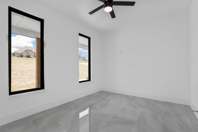 empty room with ceiling fan and plenty of natural light