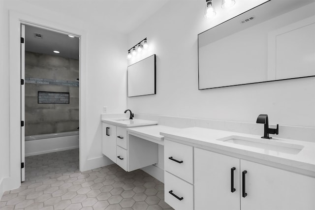 bathroom with tile patterned flooring, vanity, and tiled shower / bath