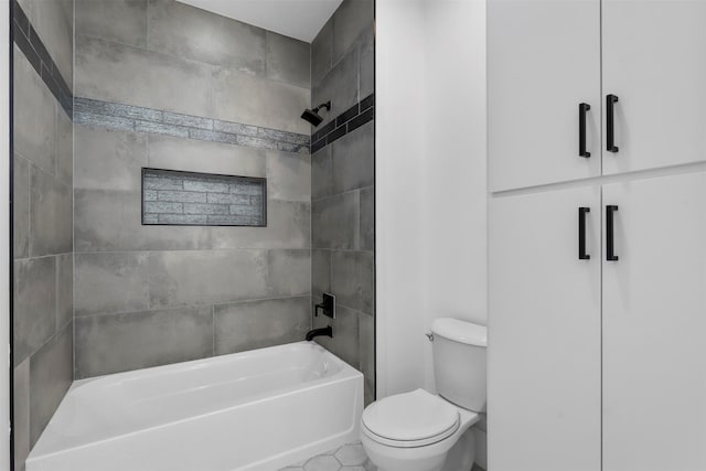 bathroom with tile patterned floors, tiled shower / bath combo, and toilet