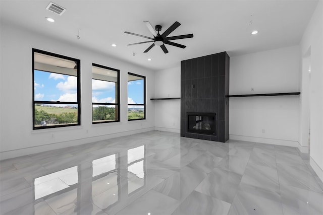 unfurnished living room with plenty of natural light, ceiling fan, and a fireplace