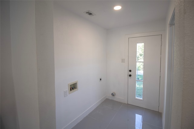 laundry room featuring electric dryer hookup, dark tile patterned floors, and washer hookup