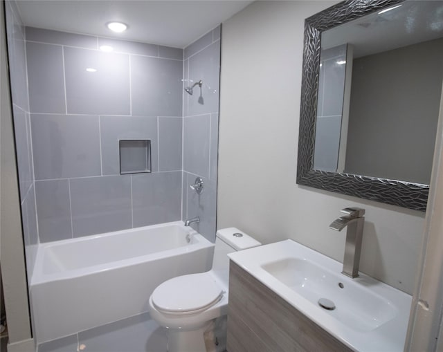 full bathroom featuring vanity, tiled shower / bath combo, and toilet