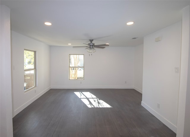 unfurnished room featuring plenty of natural light, dark hardwood / wood-style floors, and ceiling fan