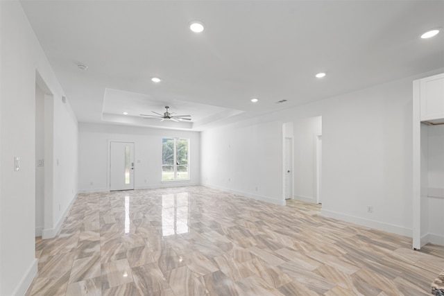 empty room with a tray ceiling and ceiling fan