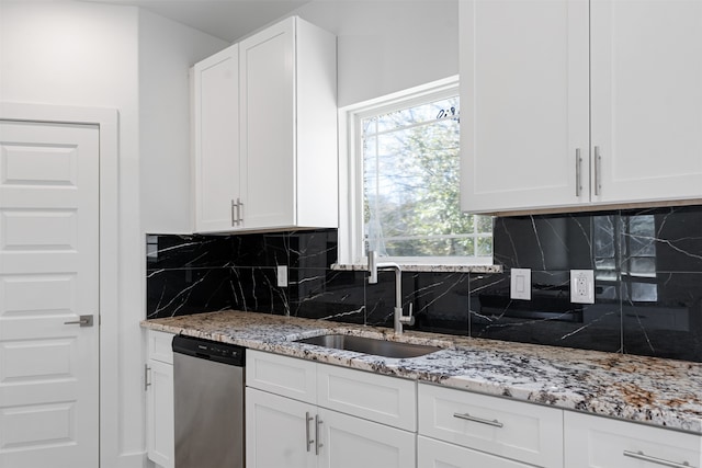 kitchen featuring decorative backsplash, light stone countertops, sink, dishwasher, and white cabinetry