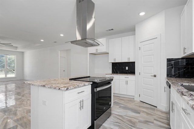 kitchen featuring a center island, light stone counters, island exhaust hood, stainless steel range with electric stovetop, and white cabinets