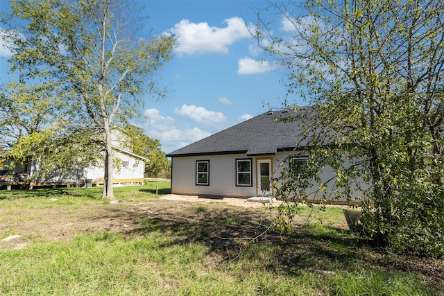 rear view of property with a yard