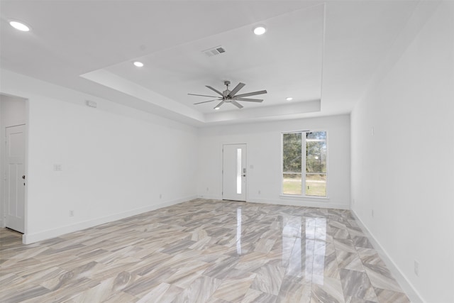 unfurnished room featuring ceiling fan and a tray ceiling