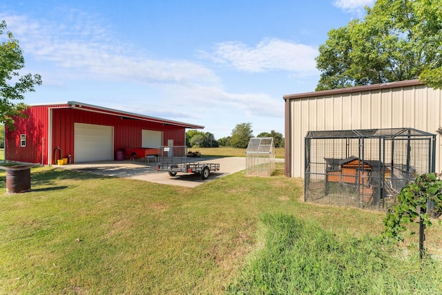 view of yard featuring a garage and an outbuilding