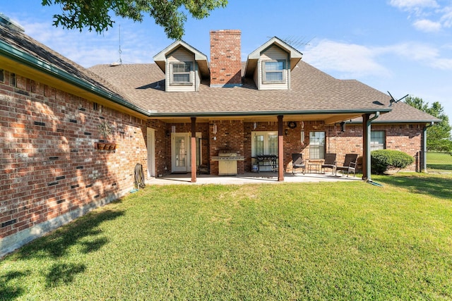 rear view of property with a lawn and a patio area